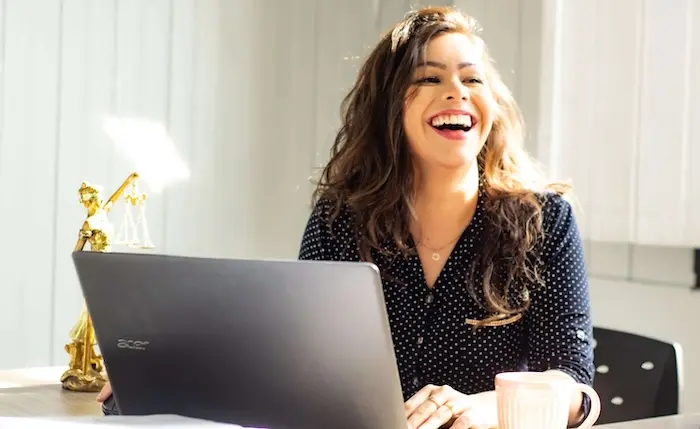 jeune femme souriante assise à son bureau